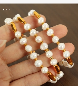 Detailed macro view of natural freshwater pearls and golden metallic tube beads