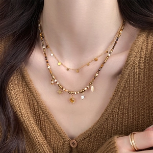 Bohemian double-layer beaded necklace with sun and star pendants on a model