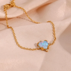 Macro shot of gold-plated heart bracelet with blue opal and sparkling zircon detail