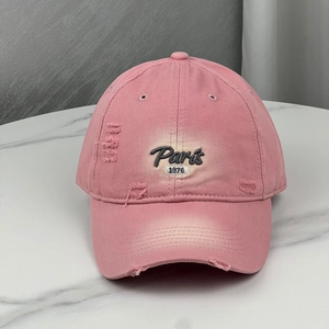 Detailed embroidery of Paris 1976 text on a pink distressed cotton baseball cap