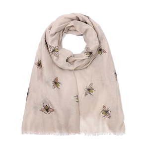 Close-up of beige bee print scarf with natural fabric texture and frayed fringe edges