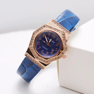 Detail of rose gold octagonal watch case with inlaid diamonds and navy leather strap