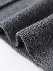 Macro shot of dark grey knit fabric showing detailed ribbed texture and wool blend fibers