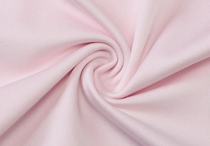 Gros plan sur un tissu en maille rose montrant une texture côtelée et élastique fine