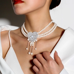 Detailed view of elegant triple-layer pearl choker with heart-shaped crystal pendant