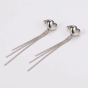 Detailed view of silver heart tassel earrings with polished finish and dangling chains