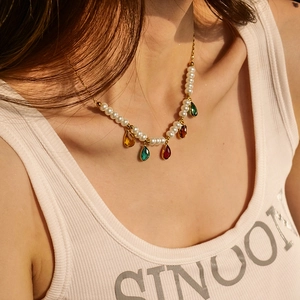 Gros plan d'un collier de perles avec des pierres précieuses colorées sur un mannequin