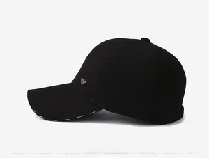 Detail of winter baseball cap with ear flaps featuring a metal plate and SPORT text