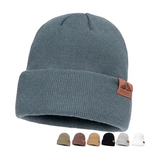 Unisex gebreide muts in blauwgrijs met omslag en een lederen bergpatch