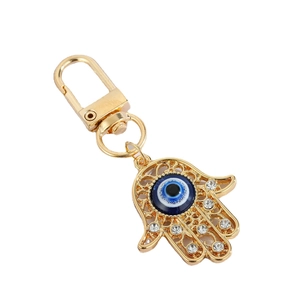 Golden Hamsa Hand keychain with blue Evil Eye bead and sparkling rhinestones