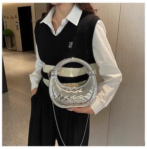 Detail of silver metallic crescent bag with woven texture and knotted handle on model