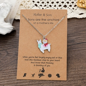 Dettaglio della collana lama Babbo Natale su biglietto regalo madre e figlio