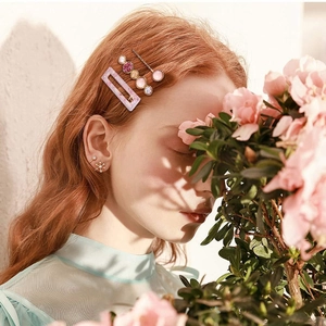 Pink marble acetate hair clip set shown on model with floral outdoor background