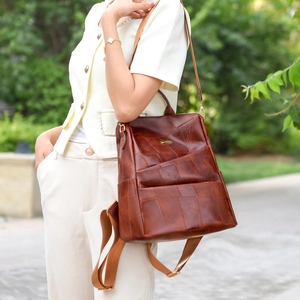Detail view of retro brown patchwork leather backpack with woven shoulder straps