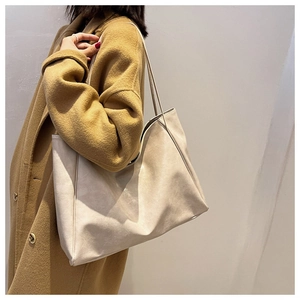 Minimalist beige tote bag shown on model wearing wool coat for daily commuting style
