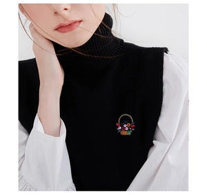 Detailed view of a vintage flower basket brooch with colorful rhinestones on a dark coat