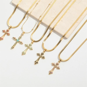 Detail of gold cross necklaces with colorful enamel finish and evil eye gemstone pendants