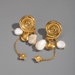Detailaufnahme der goldenen Spiralmuschel-Ohrringe mit Perlmuttschimmer-Einlage
