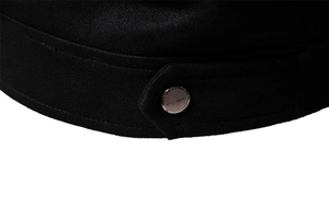 Detailed close-up of a black suede jacket with a silver metal button engraved with CLASSIC