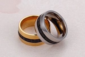 Detail of stacked gold and silver zircon rings featuring continuous black square inlay motifs