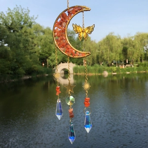 Golden crescent moon suncatcher with orange crystals and butterfly detail in nature