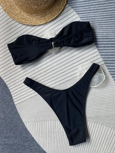 Flat lay of black bikini set featuring a silver ring detail and textured fabric