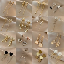 Collection of zircon animal paw earrings and minimalist studs on champagne satin fabric