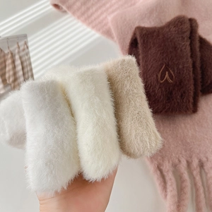Soft plush faux fur scarves in multiple colors held in hand for cozy winter fashion