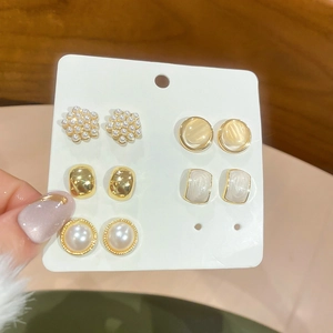 Detailed close-up of a 5-pair pearl and zircon stud earring set on a white display card