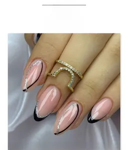 Dettaglio di unghie finte a mandorla stile French con punte nere e linee glitterate