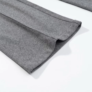 Vue macro du tissu gris à chevrons montrant les coutures fines et la texture du tissu
