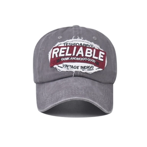 Close-up of vintage grey baseball cap featuring embroidered Reliable patch and stitching
