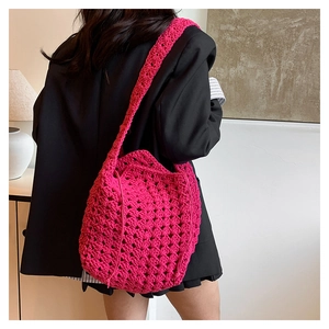 Dettaglio della borsa a spalla fucsia all'uncinetto con trama traforata e grande capacità