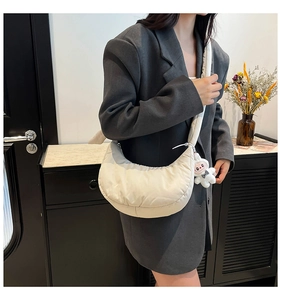 Détail du sac à bandoulière matelassé en forme de croissant ivoire avec breloque lapin