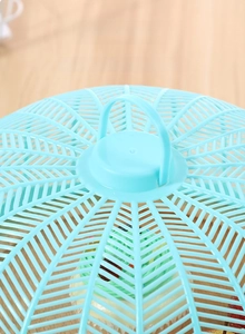 Close-up of light blue plastic food cover with hollow dome design and foldable handle