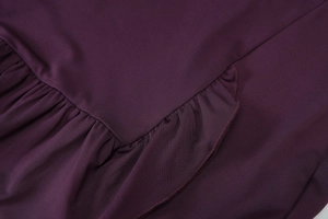 Detailed close-up of purple strapless dress fabric featuring elegant ruffled edge stitching
