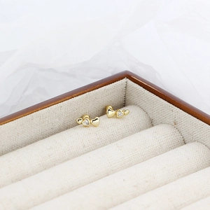 Detail of gold heart earrings with small diamonds in a wooden jewelry gift box