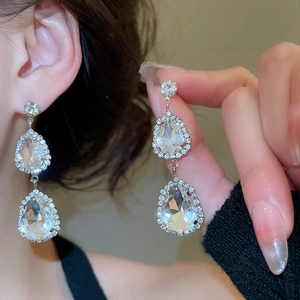 Detailed close-up of teardrop diamond earrings with silver plating and elegant sparkle