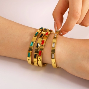 Bracelet doré orné de zircons rectangulaires colorés avec fermeture à pression sécurisée