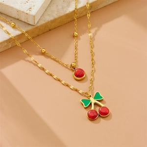 Double-layered gold chain necklace with red cherry pendants and green leaf details