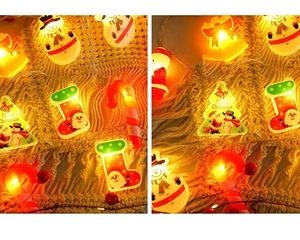 Macro detail of LED Christmas lights featuring Santa, trees and warm glowing bells