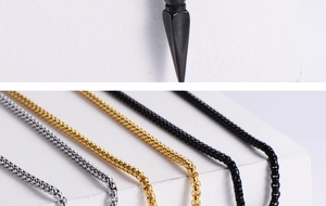 Macro detail of three-tone box chains in gold, silver, and black with a spike pendant