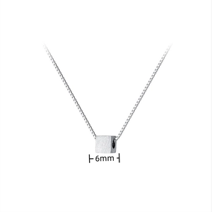 Detail view of a 6mm minimalist cube pendant on a fine silver steel box chain necklace