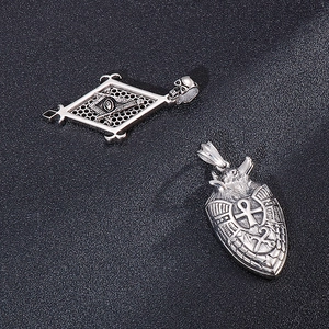 Detail of vintage steel pendants featuring Masonic Eye and Anubis on leather background