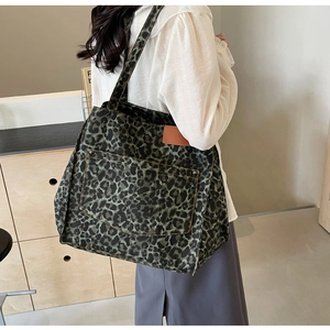 Close-up of leopard print canvas tote bag with metal rivets and leather label details