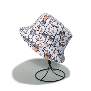 Détail d'un chapeau bob blanc en coton avec motif de canards de dessin animé et lunettes