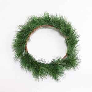 Lush green PVC pine needle wreath for Christmas tabletop decor on a white background