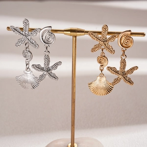 Golden and silver starfish and seashell earrings with detailed ocean textures on stands