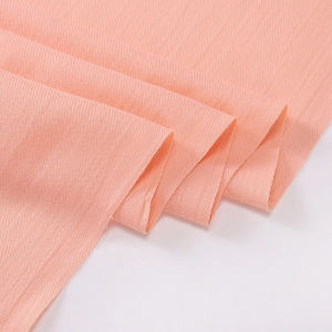 Detailed close-up of light pink cashmere-like fabric with elegant twill texture weave