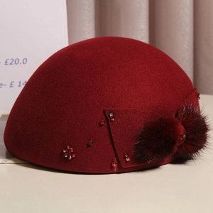 Detailed texture of burgundy wool beret with mink fur bow and sparkling rhinestone accents